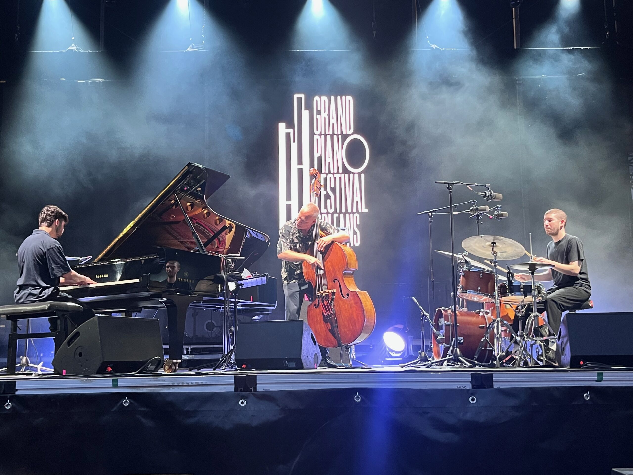 Avishai Cohen Trio en concert au Grand PianO Festival 2026, Orléans — piano, contrebasse, batterie face au logo du festival